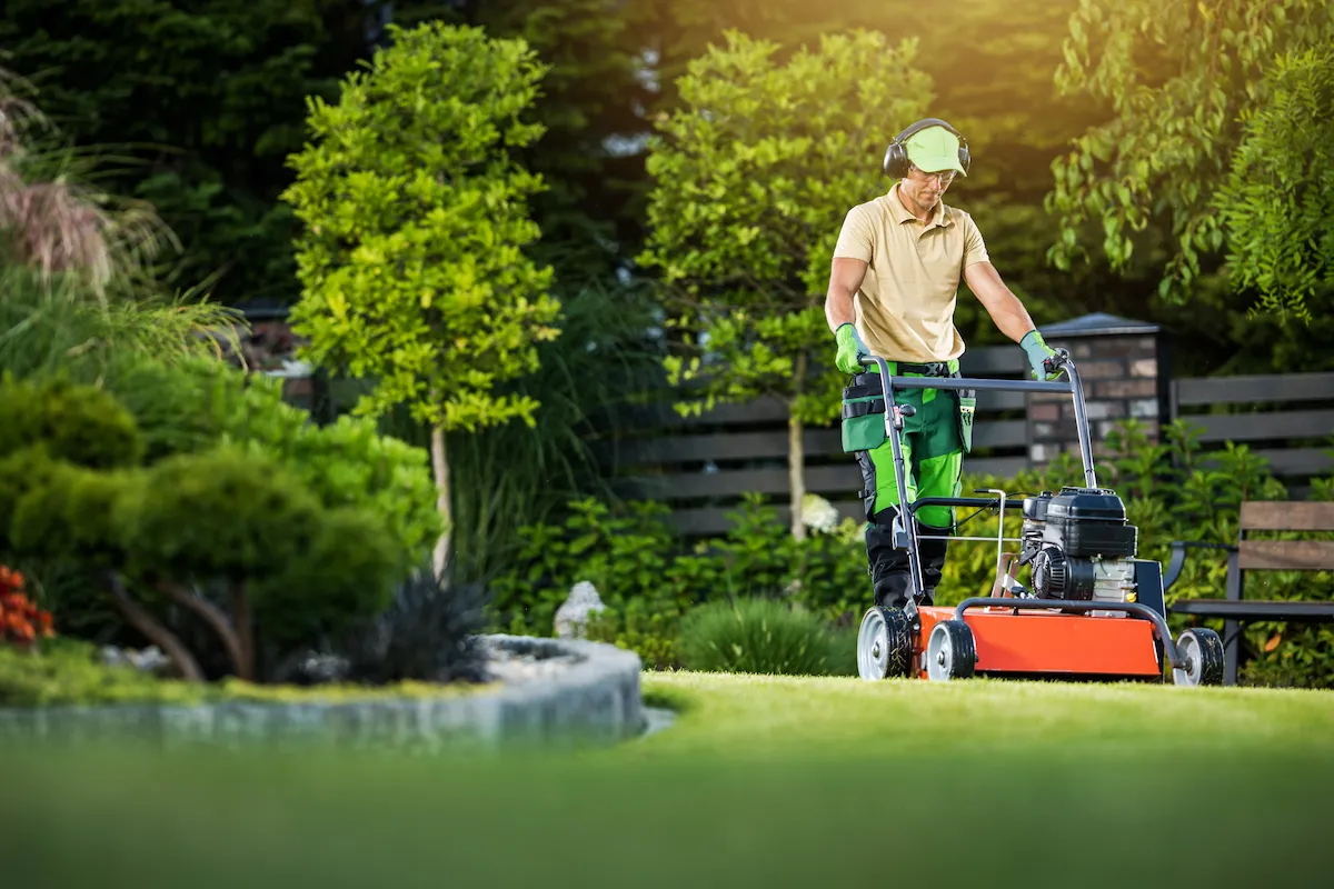 Man moving lawn using a large push lawn mower